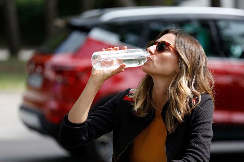Woman drinking from a reusable bottle